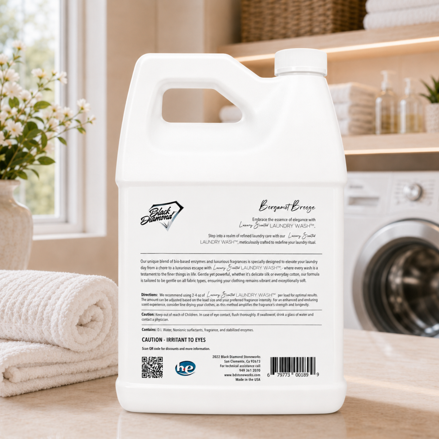 White laundry detergent bottle with label on a kitchen counter, featuring a washing machine and towels in the background.